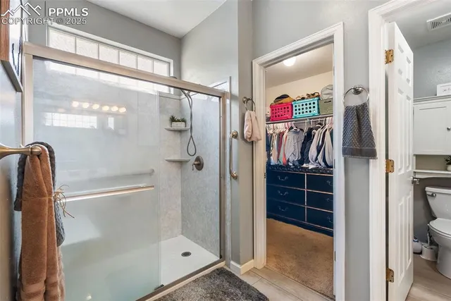 a bathroom with a toilet and a shower