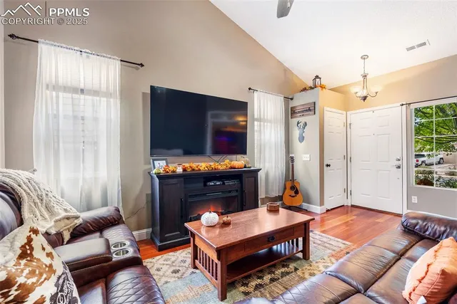 a living room with furniture a flat screen tv and a fireplace