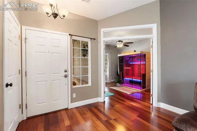 a hallway with a chandelier and a rug