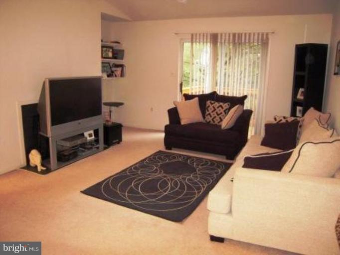 7808 Harrowgate Circle, Unit C Springfield, VA 22152 - Photo 2 of 12 a living room with furniture and a flat screen tv
