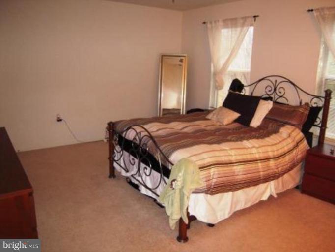 7808 Harrowgate Circle, Unit C Springfield, VA 22152 - Photo 6 of 12 a bedroom with a bed and window