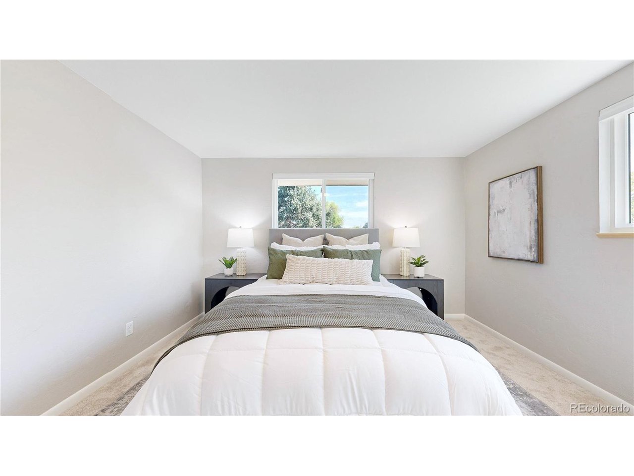 9395 West 45th Avenue Wheat Ridge, CO 80033 - Photo 19 of 48 a bedroom with a bed and a painting on the wall