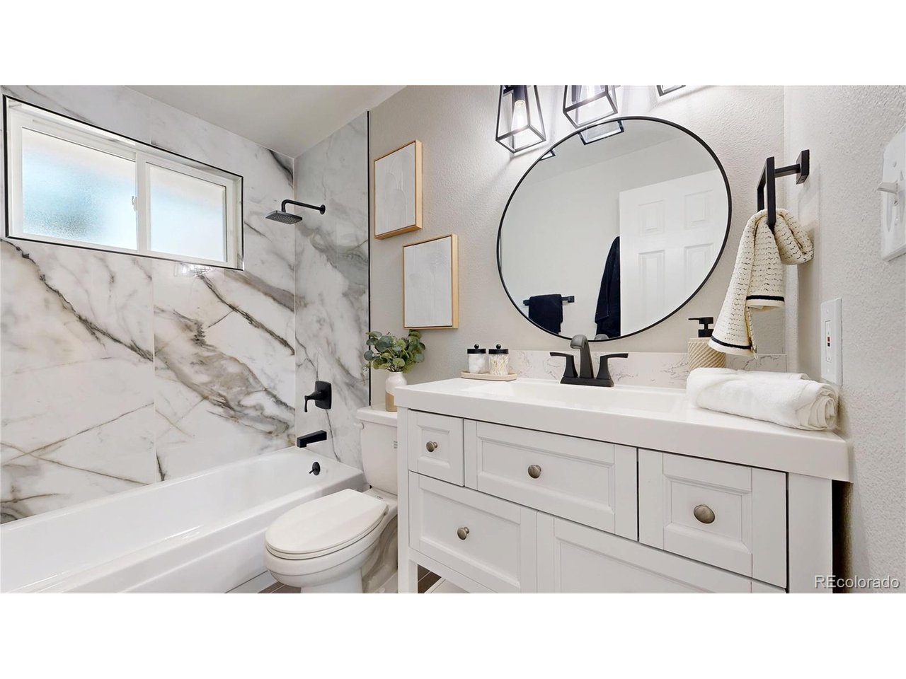 9395 West 45th Avenue Wheat Ridge, CO 80033 - Photo 23 of 48 a bathroom with a toilet a sink and mirror