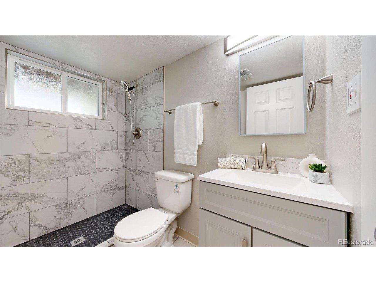 9395 West 45th Avenue Wheat Ridge, CO 80033 - Photo 30 of 48 a bathroom with a sink toilet a mirror and shower