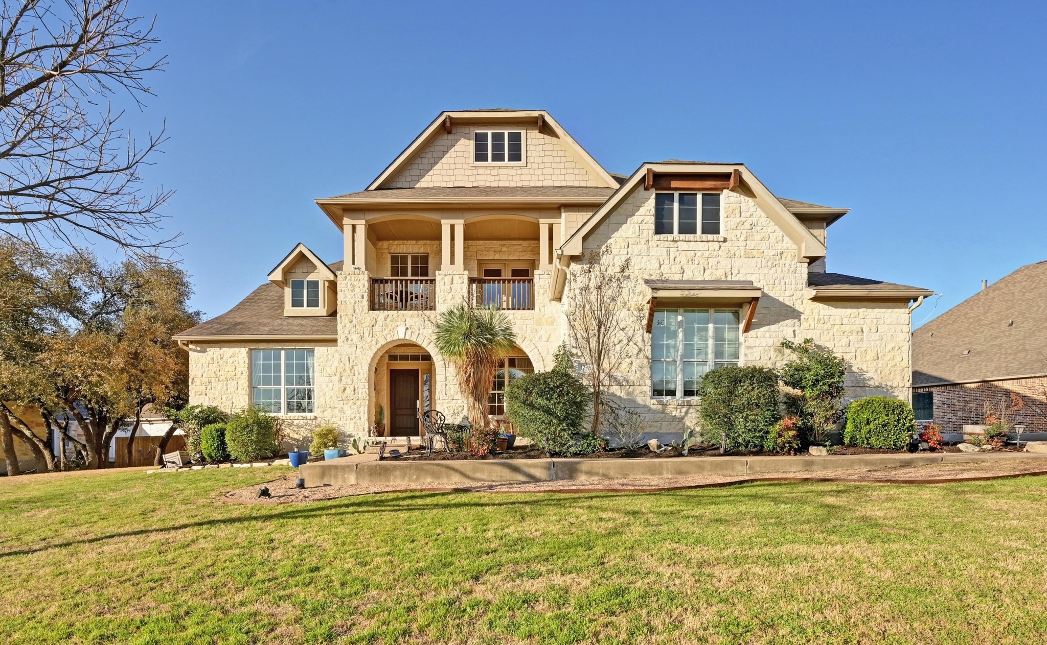 1732 Grassy Field Road Austin, TX 78737 - Photo 1 of 1 View of front of home with a front yard, a balcony, and stone siding