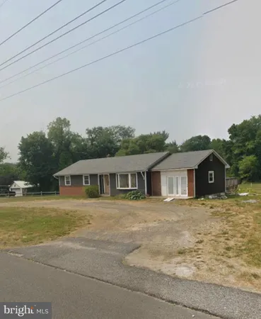 a view of a house with a big yard and large trees