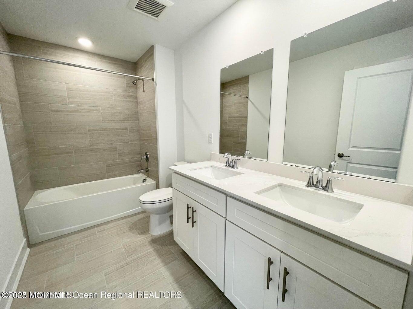 106 Woolley Court Oakhurst, NJ 07755 - Photo 5 of 17 a bathroom with a double vanity sink toilet mirror and bathtub