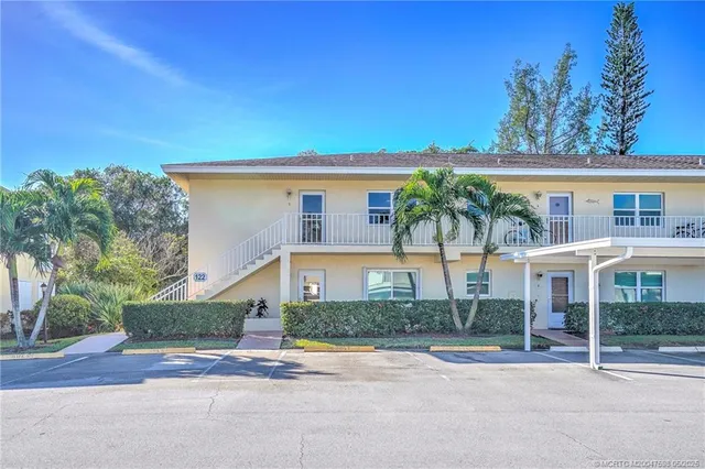 a front view of a house with a yard and potted plants