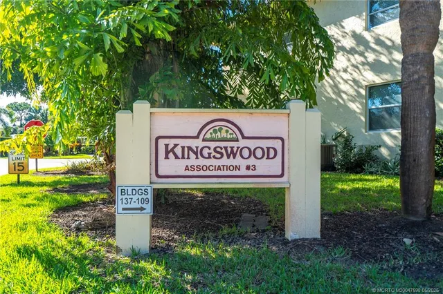 a dining hall with stainless steel appliances kitchen island a table and chairs in it