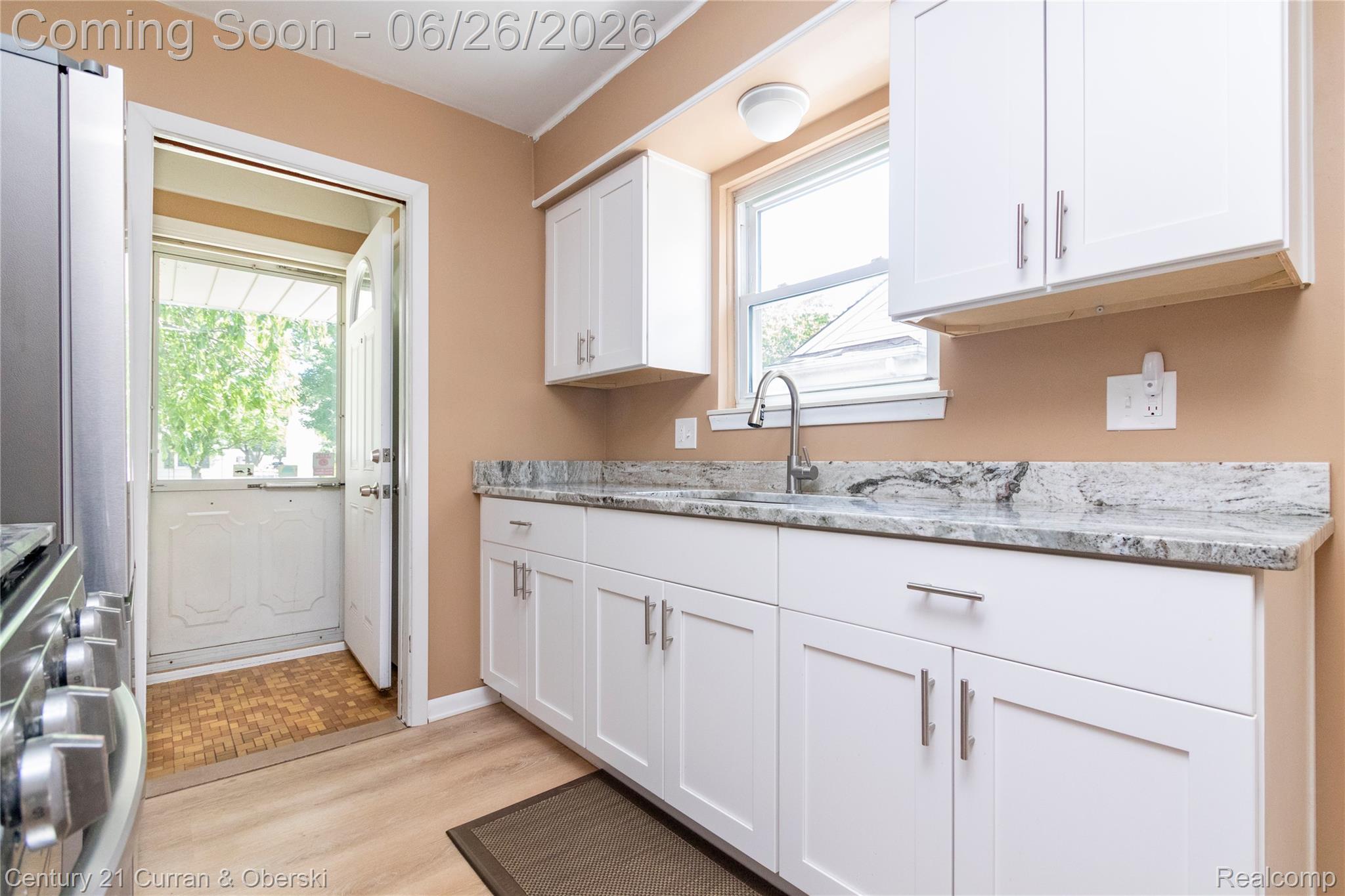 3220 Alice Street Dearborn, MI 48124 - Photo 10 of 39 Updated kitchen featuring white shaker cabinetry, speckled countertops, and a stainless steel gooseneck faucet
