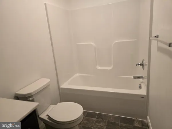 a white toilet sitting next to a bath tub