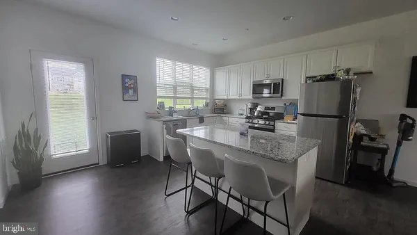 a kitchen with a table chairs refrigerator and window