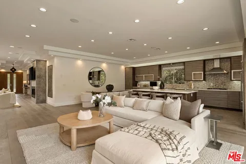 a kitchen with a sink stainless steel appliances and living room view