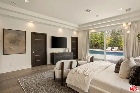 a spacious bathroom with a double vanity sink toilet mirror and shower