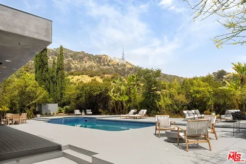 a view of a patio with couches table and chairs and potted plants
