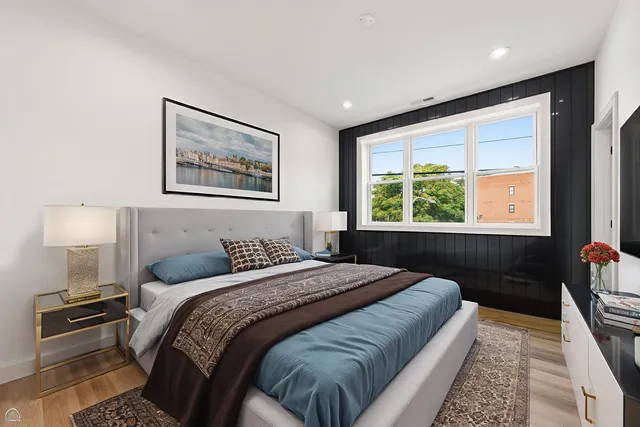 a bedroom with a bed and a lamp on dresser