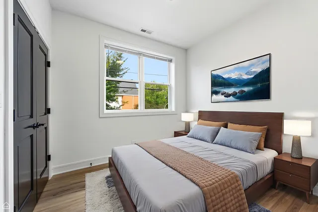 a bedroom with a bed and a painting on the wall