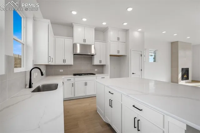 a kitchen with kitchen island granite countertop a sink stainless steel appliances and cabinets