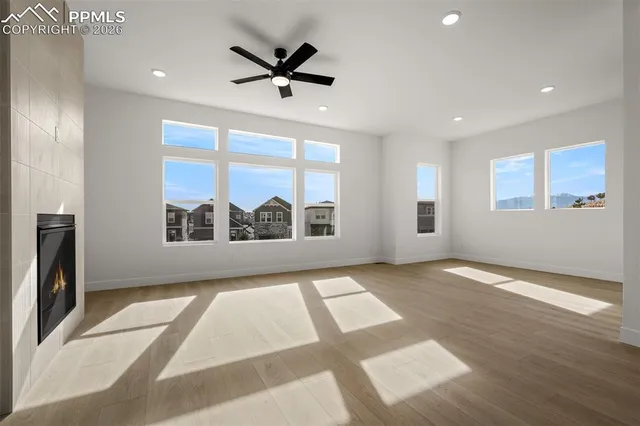 a view of an empty room with a window and a fireplace