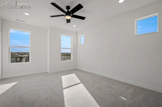 an empty room with a window and a ceiling fan