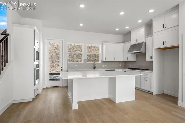 a large kitchen with stainless steel appliances kitchen island granite countertop a stove and a sink