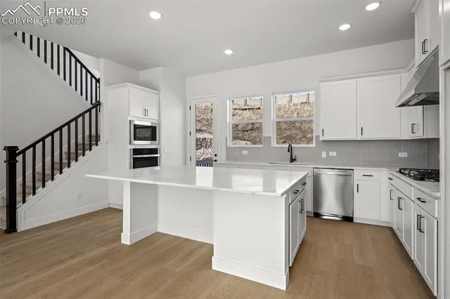 a kitchen with stainless steel appliances granite countertop a stove and a sink