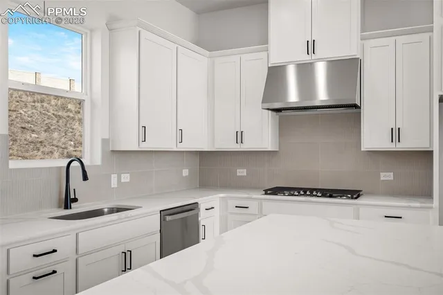 a kitchen with stainless steel appliances a sink a stove and cabinets