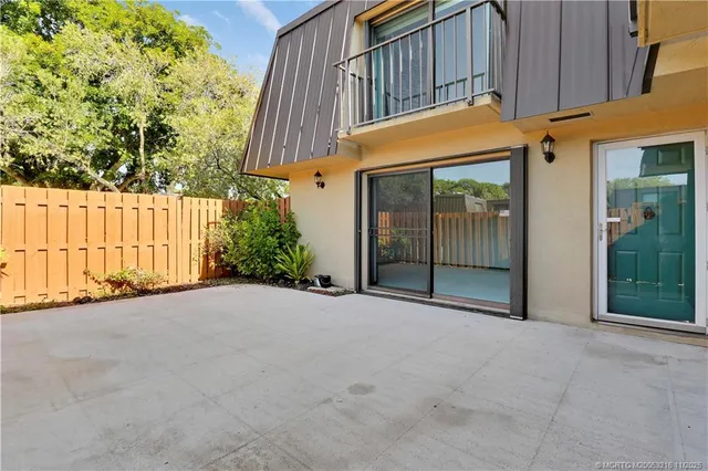 a view of a house with a door and wooden fence