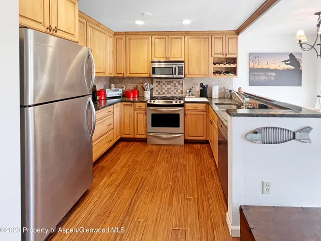 a kitchen with a refrigerator a stove a sink and a microwave