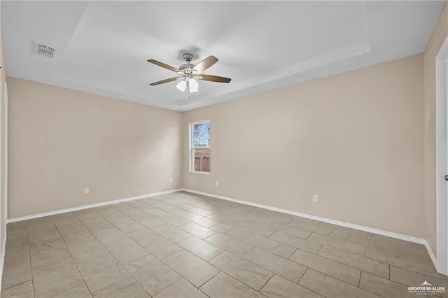 an empty room with windows and fan