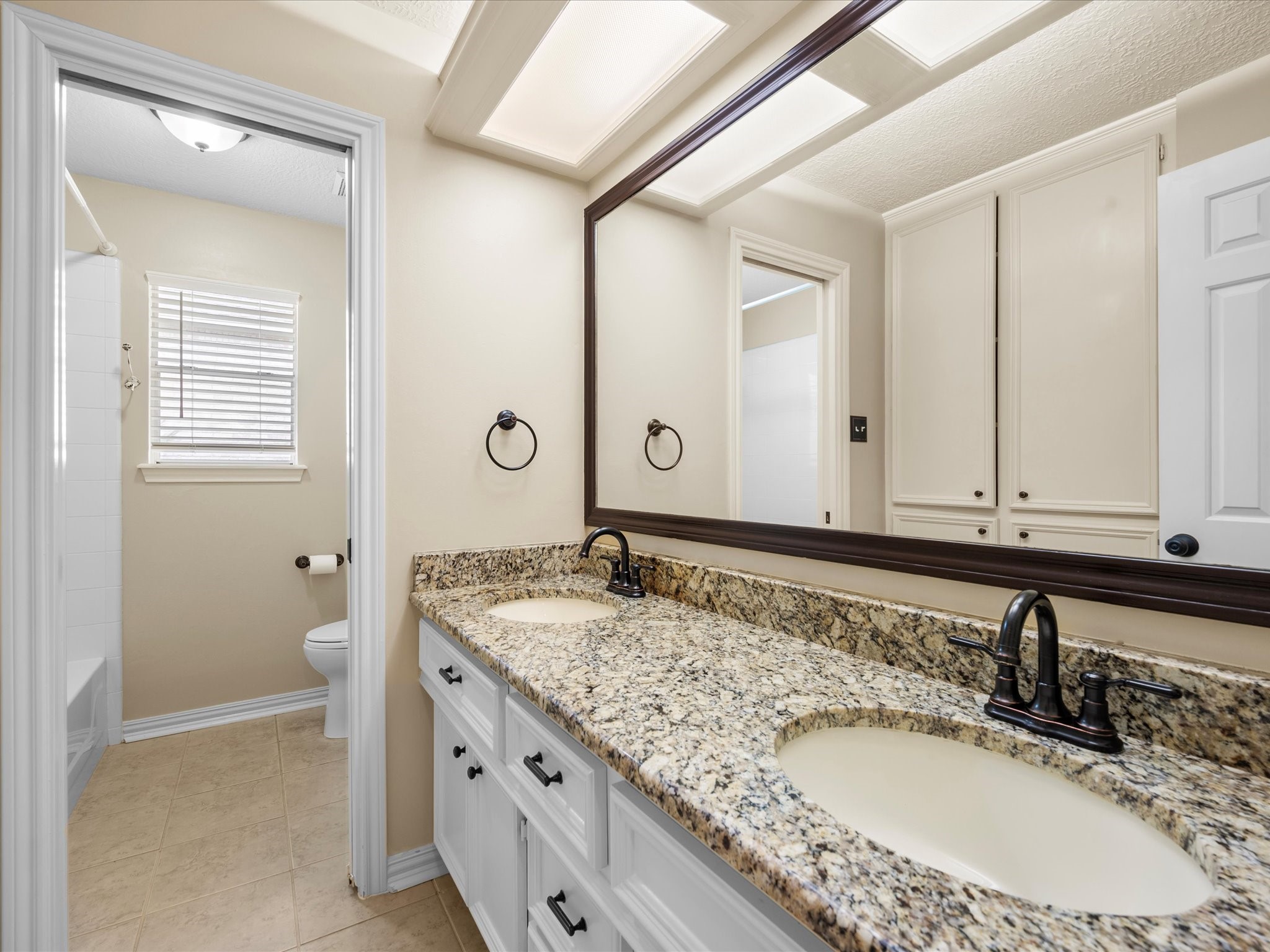 7 Wellesley Drive Conroe, TX 77304 - Photo 20 of 34 a bathroom with a granite countertop double vanity sink and a mirror
