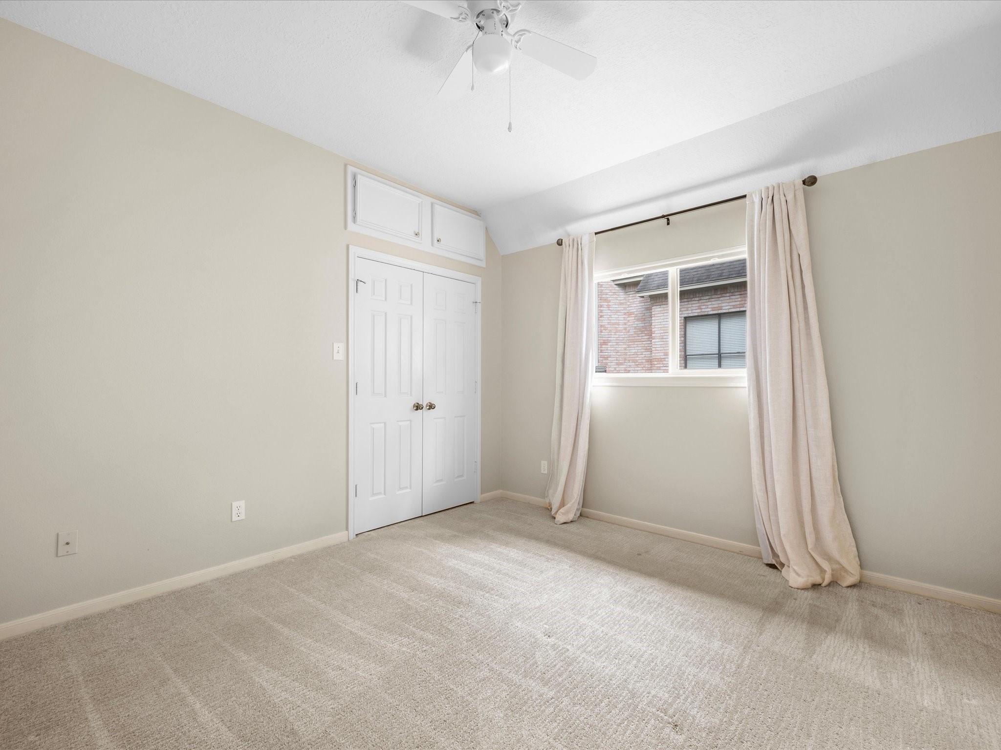 7 Wellesley Drive Conroe, TX 77304 - Photo 21 of 34 an empty room with a ceiling fan and a window