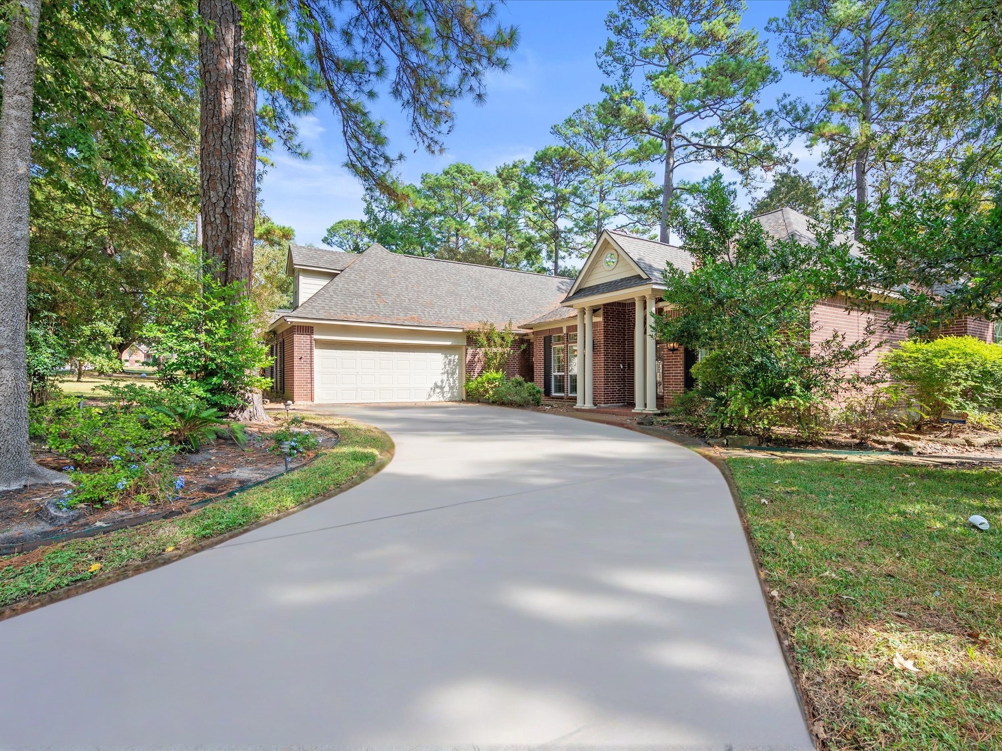 7 Wellesley Drive Conroe, TX 77304 - Photo 33 of 34 a front view of a house with a yard and potted plants