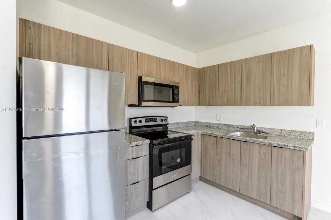 339 West 78th Road, Unit 203 Hialeah, FL 33014 - Photo 13 of 23 a kitchen with a refrigerator sink and microwave