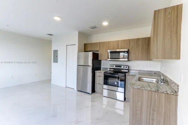a kitchen with stainless steel appliances a refrigerator and a stove top oven