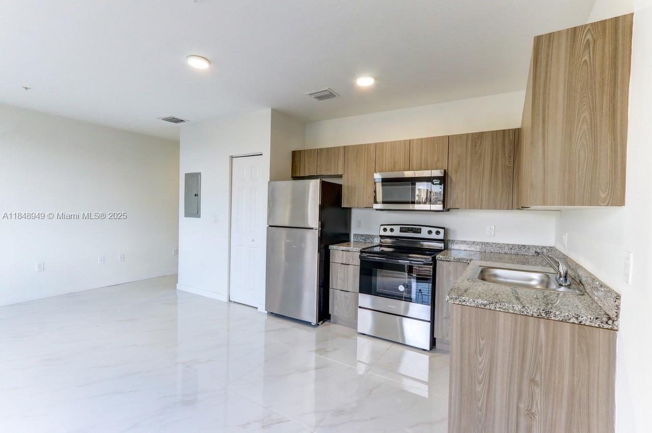339 West 78th Road, Unit 203 Hialeah, FL 33014 - Photo 17 of 23 a kitchen with stainless steel appliances granite countertop a refrigerator and a stove top oven