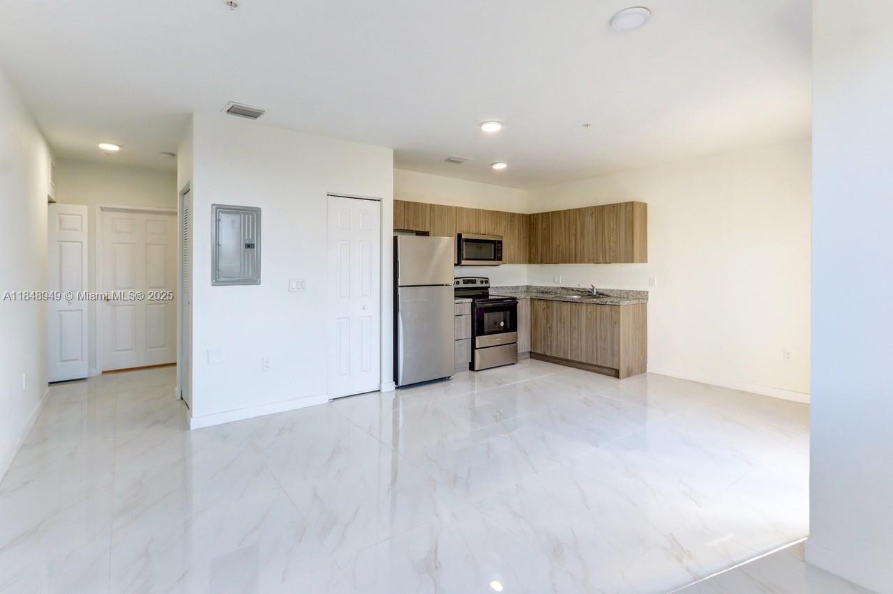 339 West 78th Road, Unit 203 Hialeah, FL 33014 - Photo 18 of 23 a view of a kitchen with a sink and dishwasher a refrigerator a fireplace