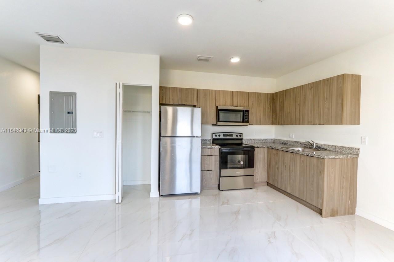 339 West 78th Road, Unit 203 Hialeah, FL 33014 - Photo 19 of 23 a kitchen with stainless steel appliances a refrigerator and a stove top oven