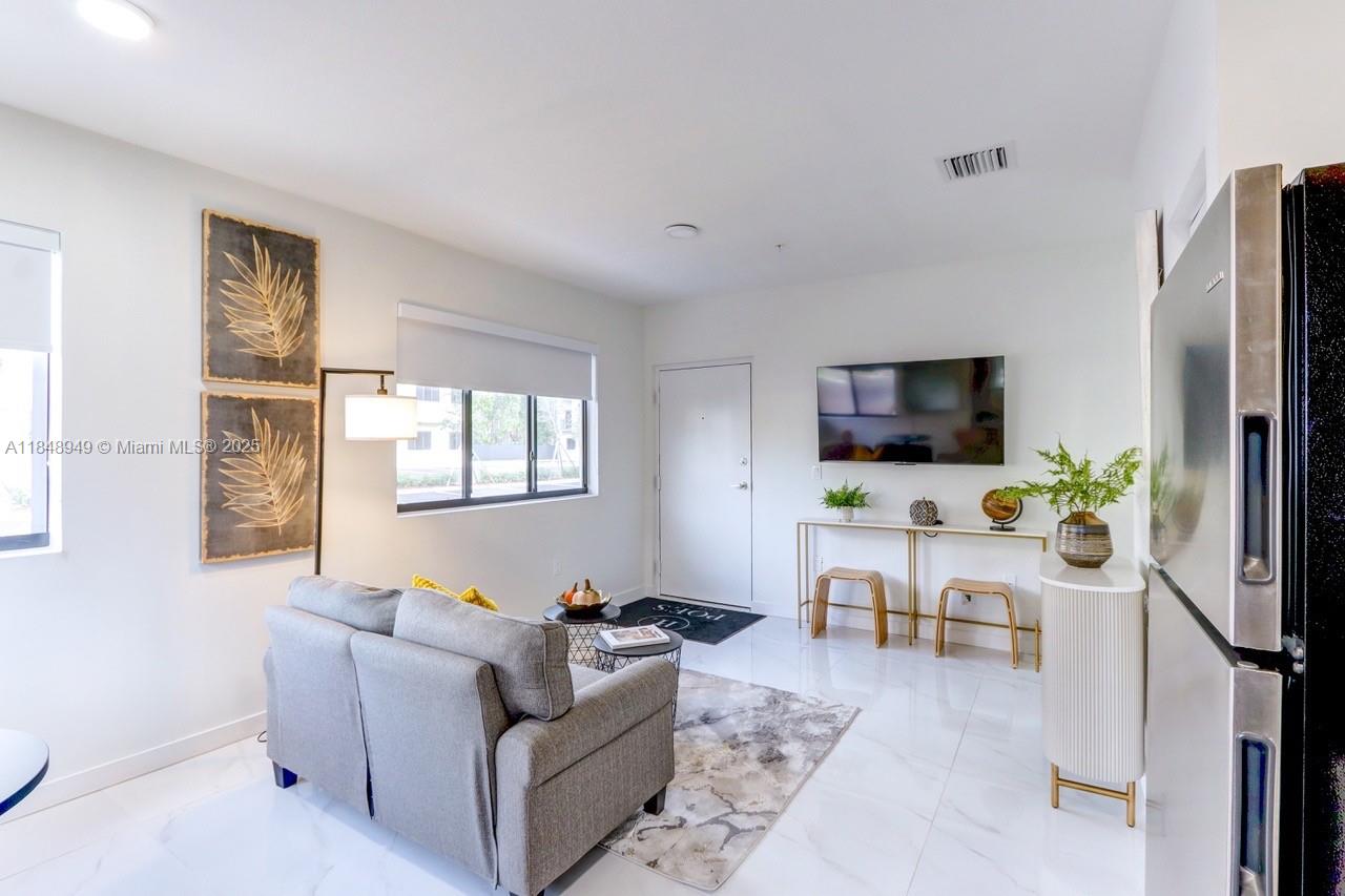 339 West 78th Road, Unit 203 Hialeah, FL 33014 - Photo 6 of 23 a living room with furniture a flat screen tv and a window