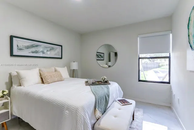 a bedroom with a bed and a painting on the wall