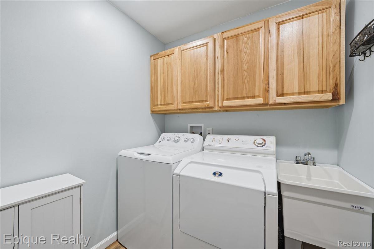 1221 Rhodes Road Lake Orion, MI 48360 - Photo 44 of 72 Laundry area featuring light wood cabinetry, a utility sink with chrome faucet, and wood-finish flooring