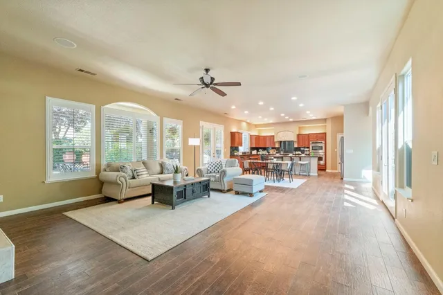 a living room with furniture and a table with wooden floor