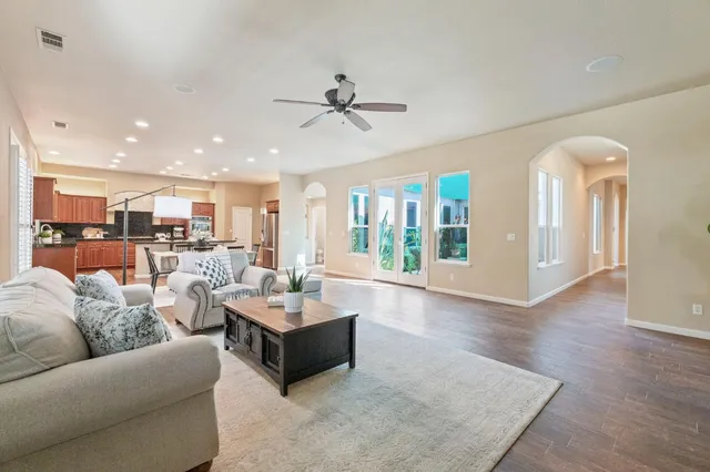 a living room with furniture kitchen view and a large window