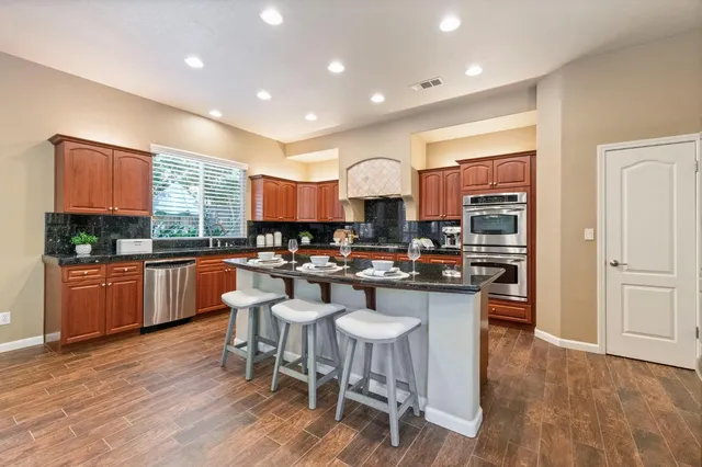 a kitchen with a sink cabinets and wooden floor