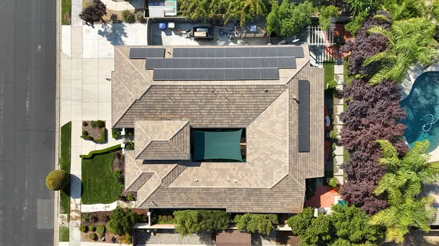 an aerial view of a city with lots of residential buildings ocean and mountain view in back