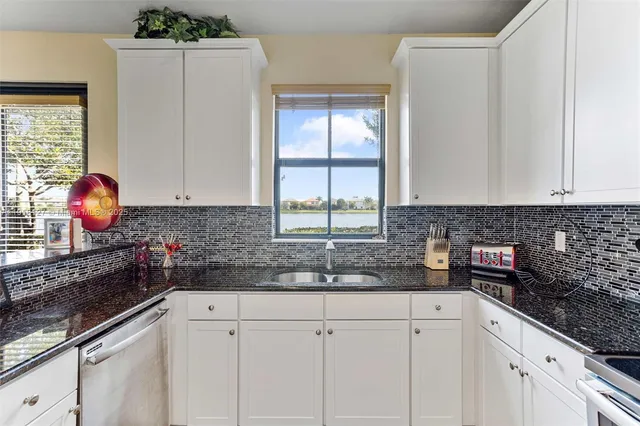 a kitchen with stainless steel appliances granite countertop a sink and a granite counter tops