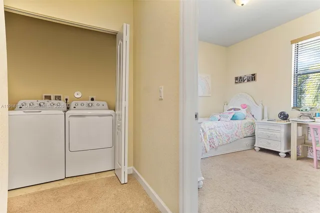 a room with a bed and white cabinets