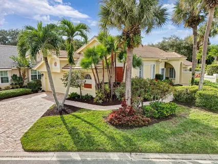 a view of a house with a yard and potted plants