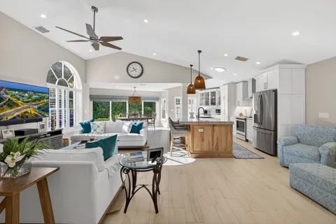 a living room with furniture a flat screen tv and a large window