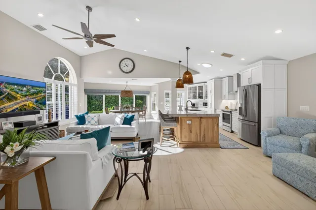 a living room with furniture a flat screen tv and a large window